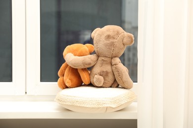 Photo of Teddy bears on window sill at home, back view