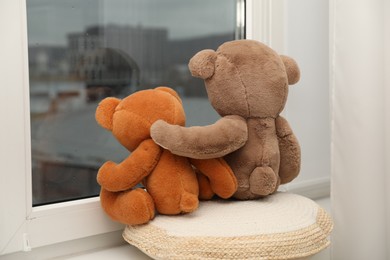 Photo of Teddy bears on window sill at home, back view