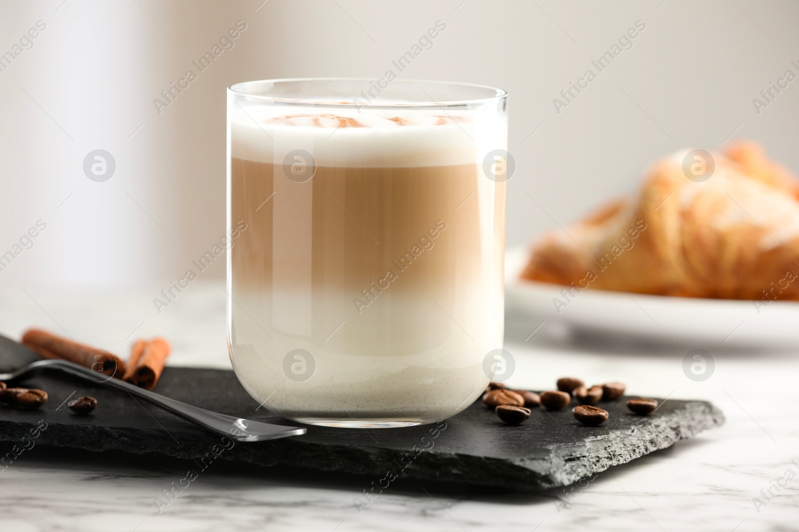 Photo of Tasty latte macchiato in glass on marble table, closeup. Coffee drink