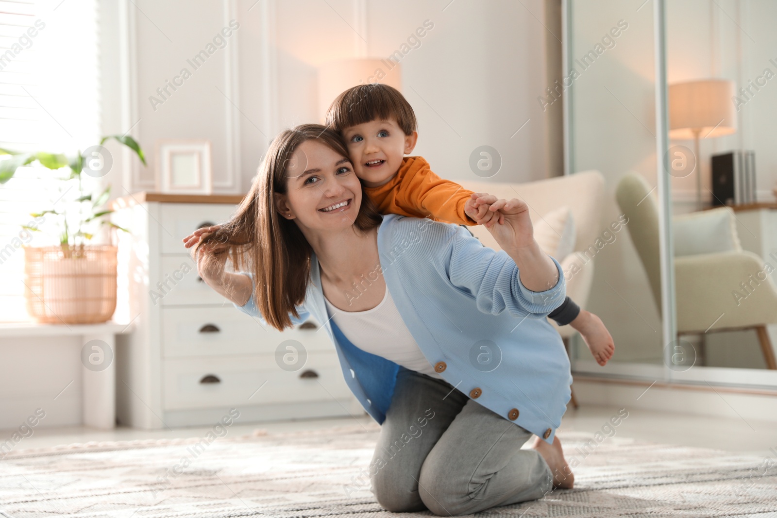 Photo of Happy mother playing with her little son at home