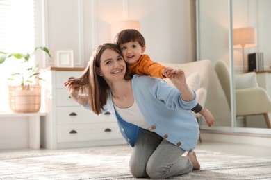 Photo of Happy mother playing with her little son at home