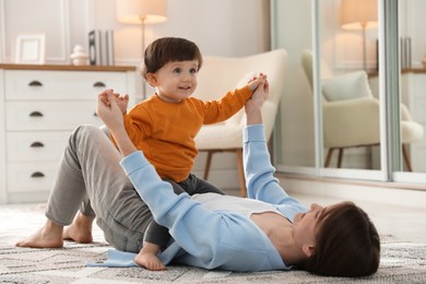 Photo of Mother playing her happy little son at home