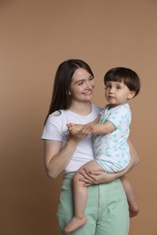 Photo of Family portrait of happy mother with her little son on beige background