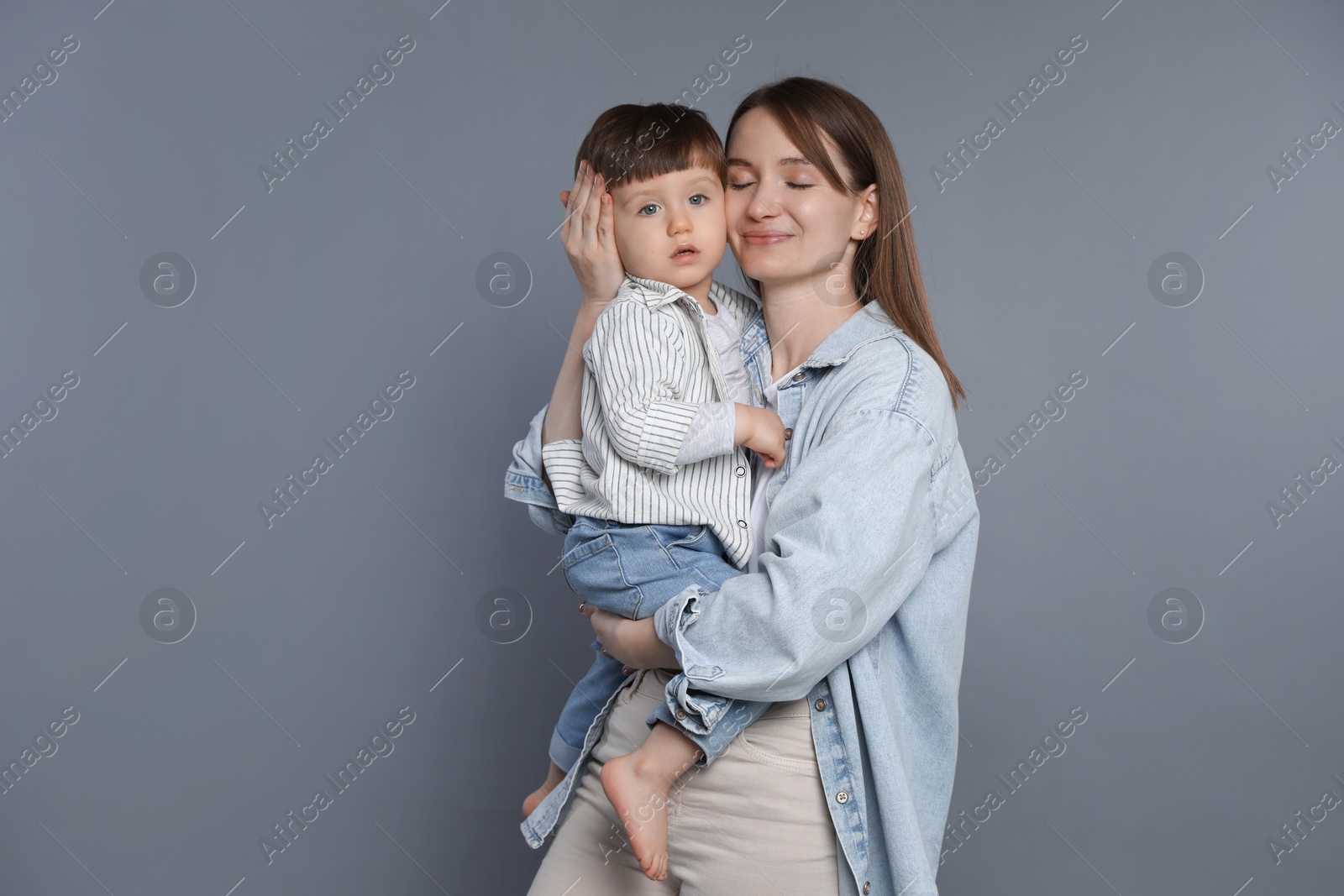 Photo of Mother with her little son on grey background. Space for text