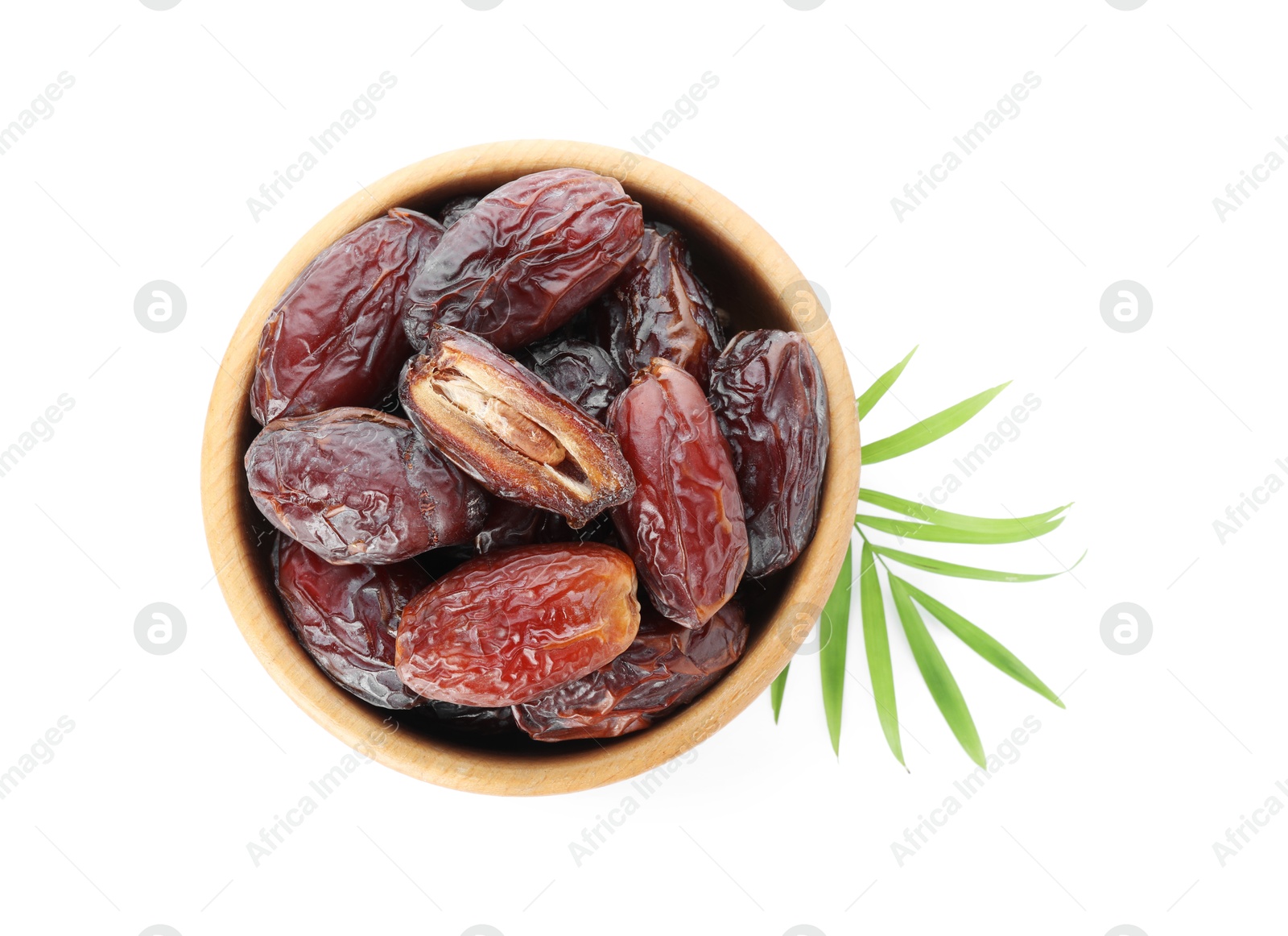 Photo of Tasty dried dates and leaf in bowl isolated on white, top view