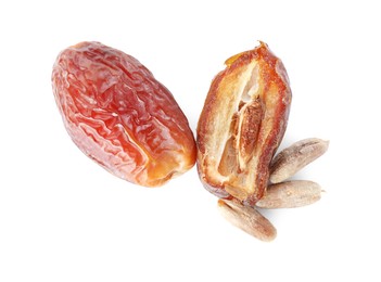 Photo of Pieces of dried dates and seeds isolated on white, top view