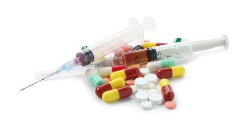 Photo of Drug addiction. Different pills and syringes isolated on white