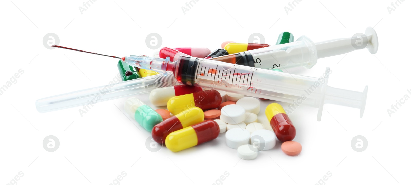 Photo of Drug addiction. Different pills and syringes isolated on white