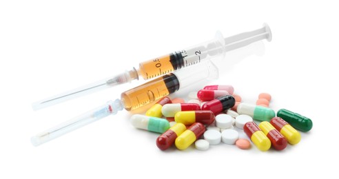 Photo of Drug addiction. Different pills and syringes isolated on white