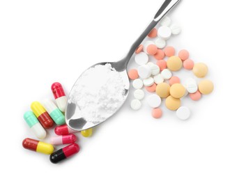 Photo of Drug addiction. Different pills and spoon with powder isolated on white, top view