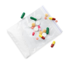 Photo of Drug addiction. Different pills and plastic bag with powder isolated on white, top view