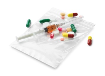 Photo of Drug addiction. Different pills, plastic bag with powder and syringe isolated on white