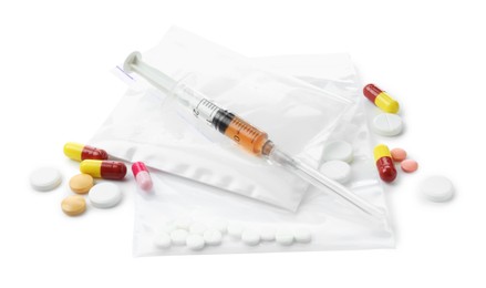 Photo of Drug addiction. Different pills, plastic bags with powder and syringe isolated on white