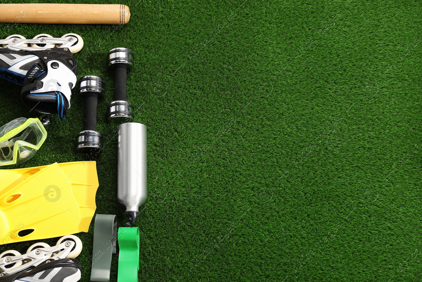 Photo of Different sport equipment on artificial grass, flat lay. Space for text