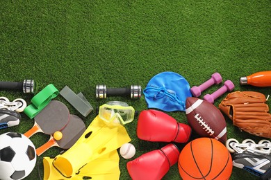 Photo of Different sport equipment on artificial grass, flat lay. Space for text