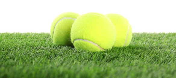 Photo of Tennis balls on artificial grass isolated on white. Sport equipment