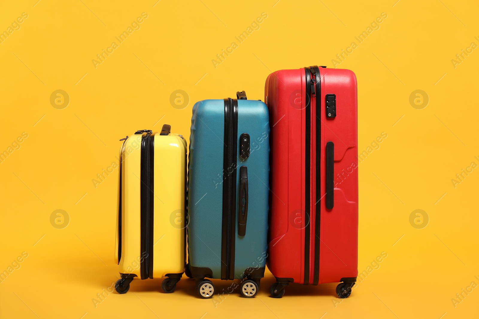 Photo of Many closed colorful suitcases on orange background