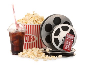 Photo of Tasty popcorn, film reels, soda drink and movie ticket isolated on white