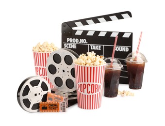 Photo of Tasty popcorn, film reels, clapper, soda drinks and movie tickets isolated on white