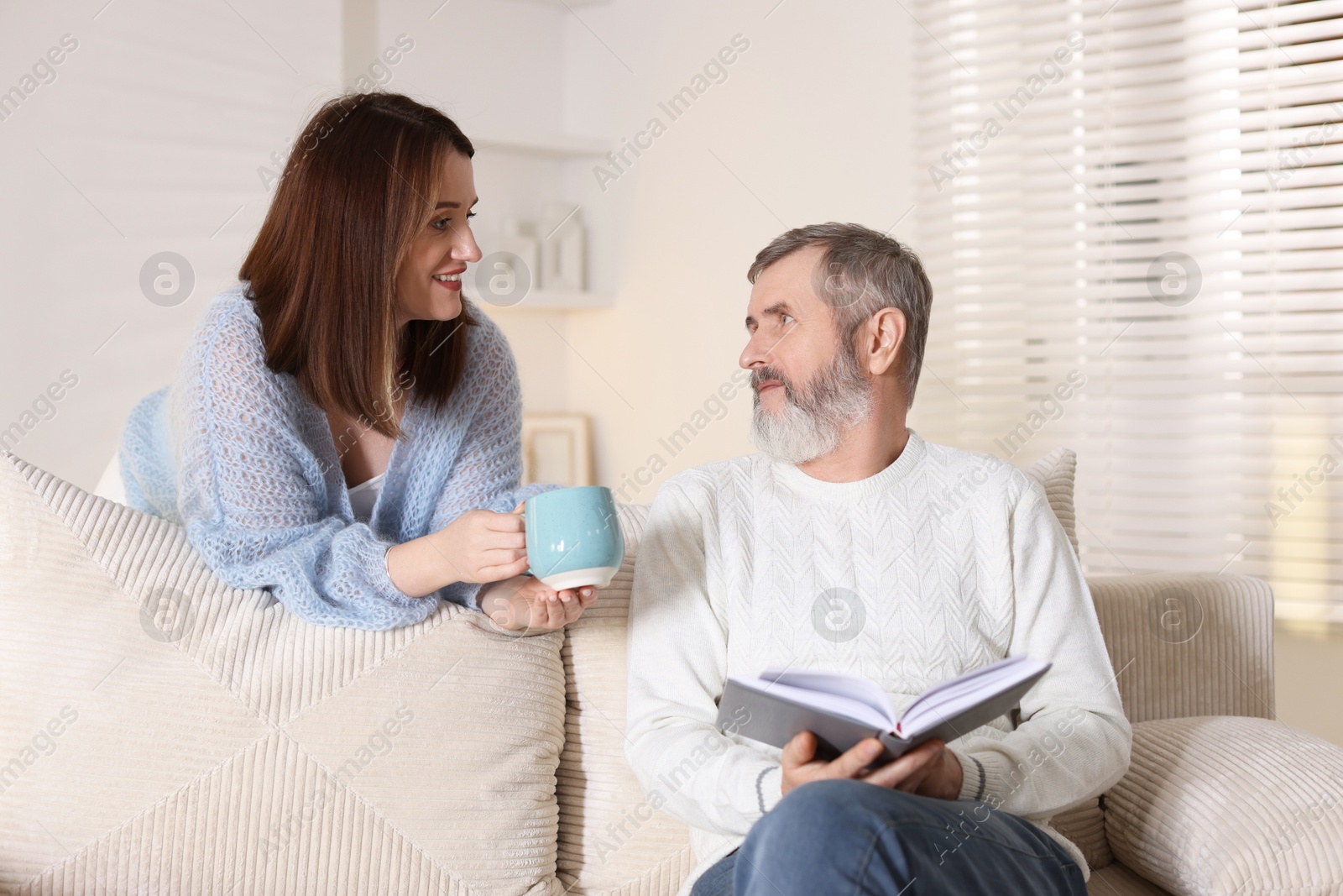 Photo of Happy adult daughter and her father spending time together at home