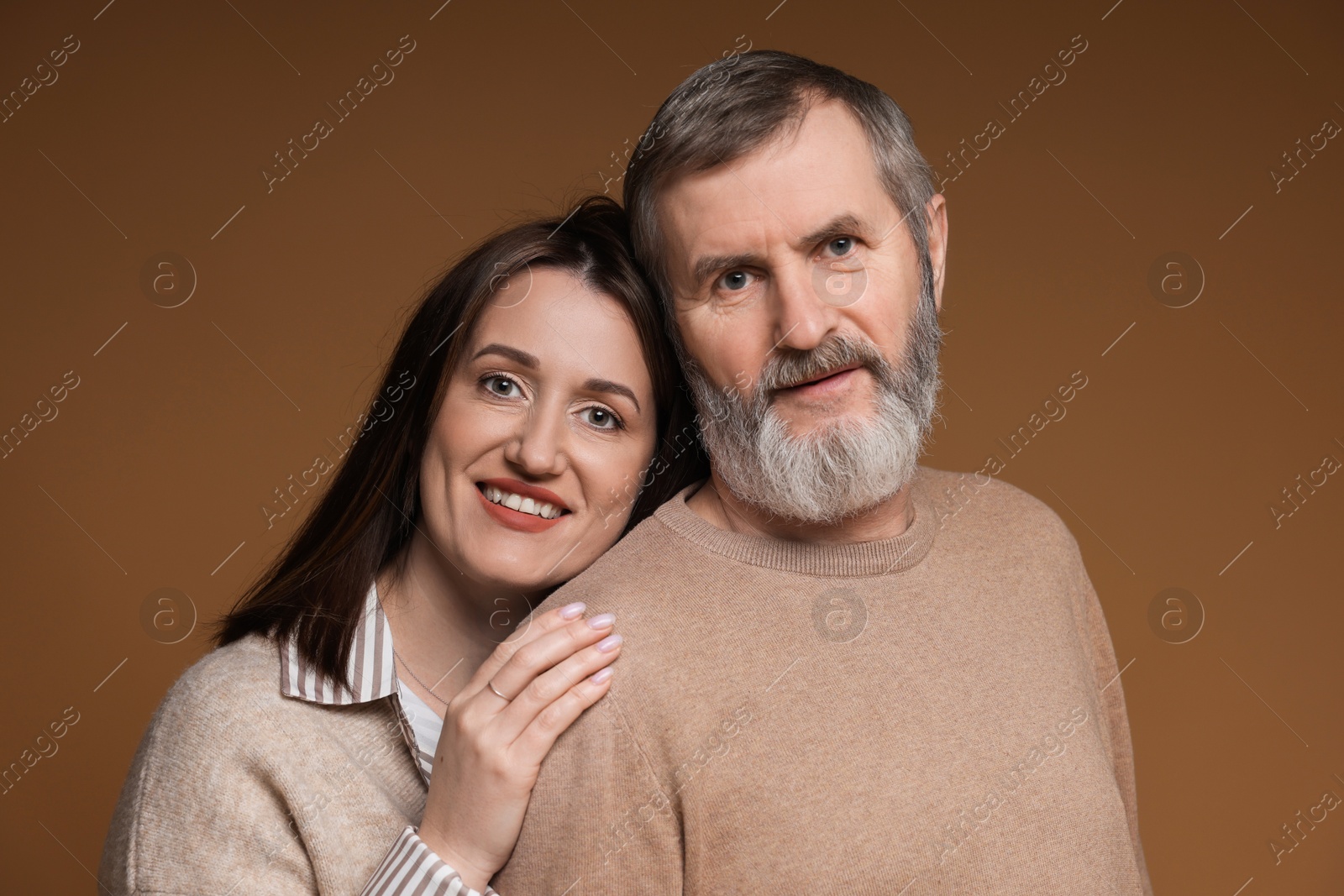 Photo of Family portrait of happy daughter and her father on brown background