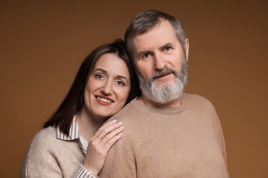 Photo of Family portrait of happy daughter and her father on brown background