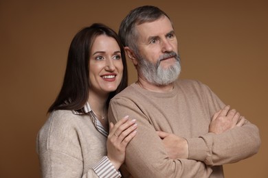 Photo of Happy daughter and her father on brown background