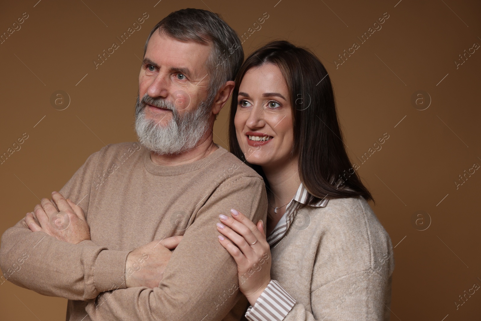 Photo of Happy daughter and her father on brown background