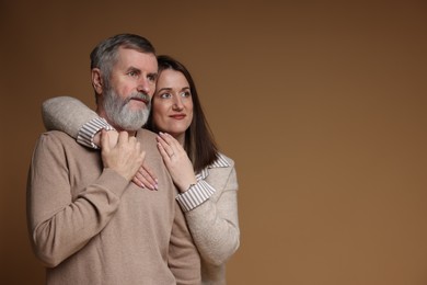 Photo of Happy daughter and her father on brown background, space for text