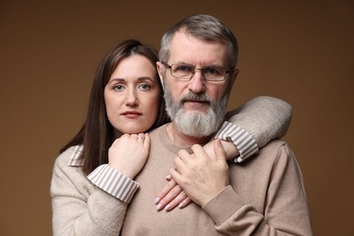 Photo of Family portrait of father and his daughter on brown background