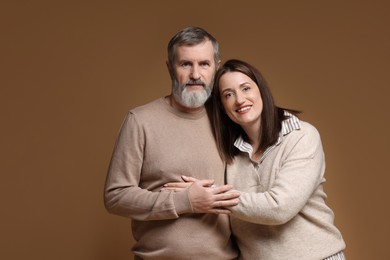 Photo of Family portrait of happy daughter and her father on brown background, space for text