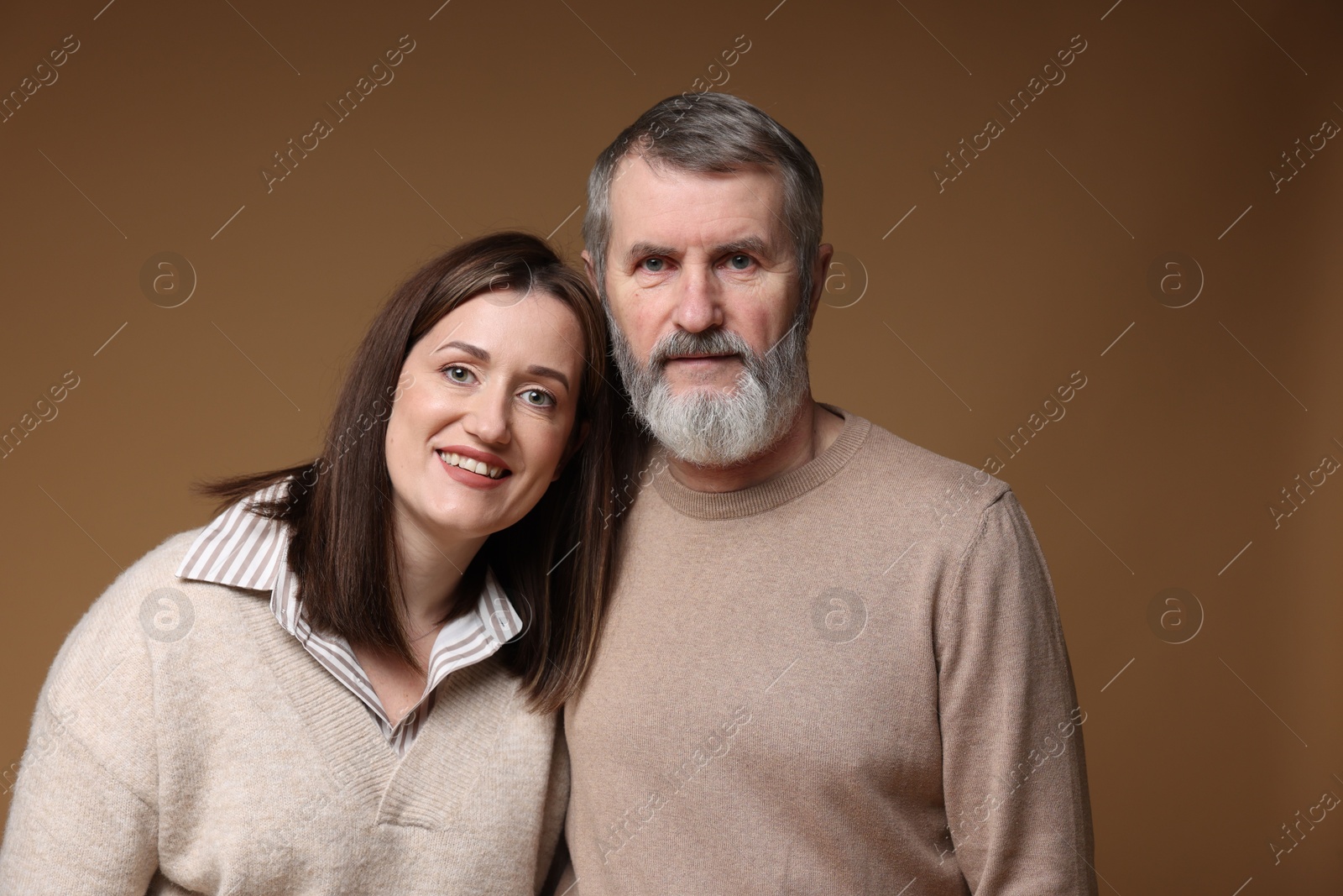 Photo of Family portrait of happy daughter and her father on brown background