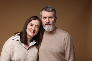 Photo of Family portrait of happy daughter and her father on brown background