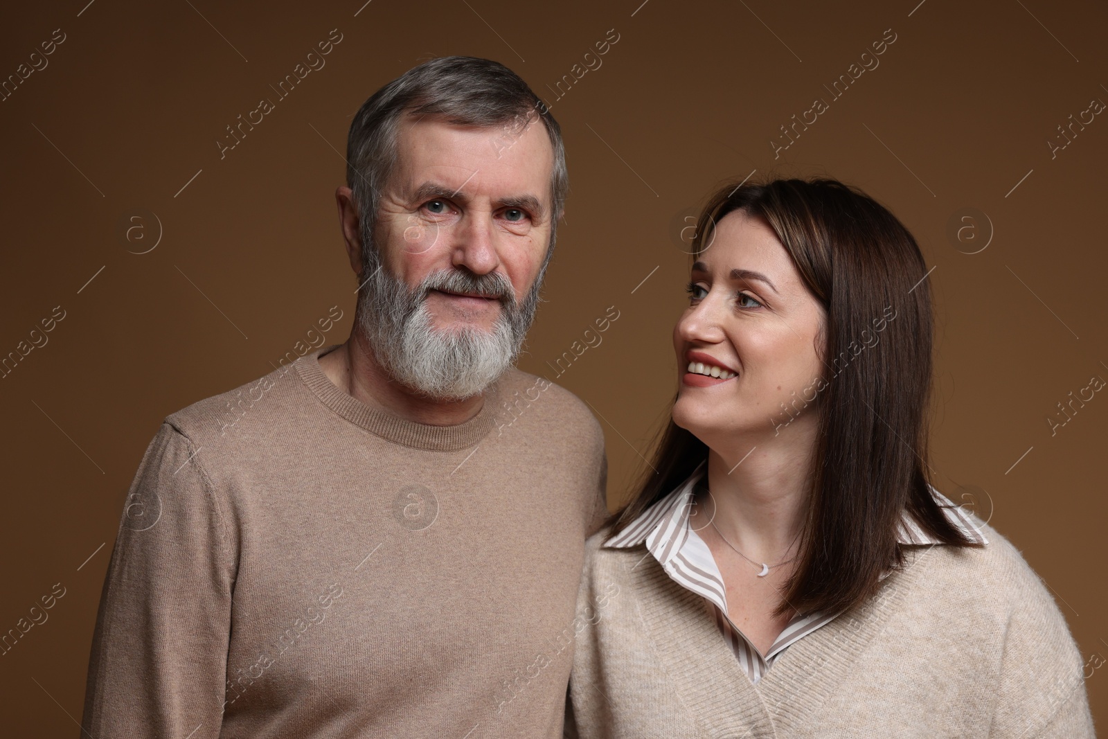 Photo of Happy daughter and her father on brown background