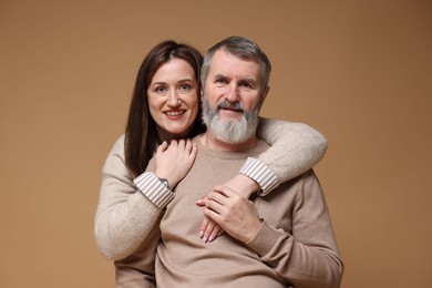 Photo of Family portrait of happy daughter and her father on light brown background