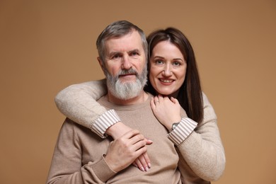 Photo of Family portrait of happy daughter and her father on light brown background