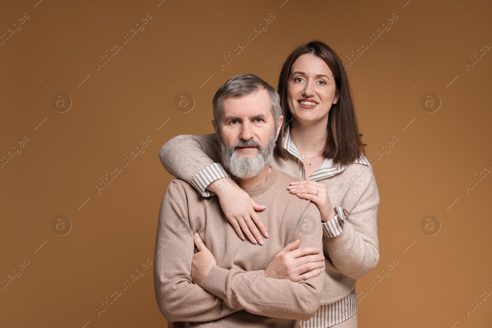 Photo of Family portrait of happy daughter and her father on brown background