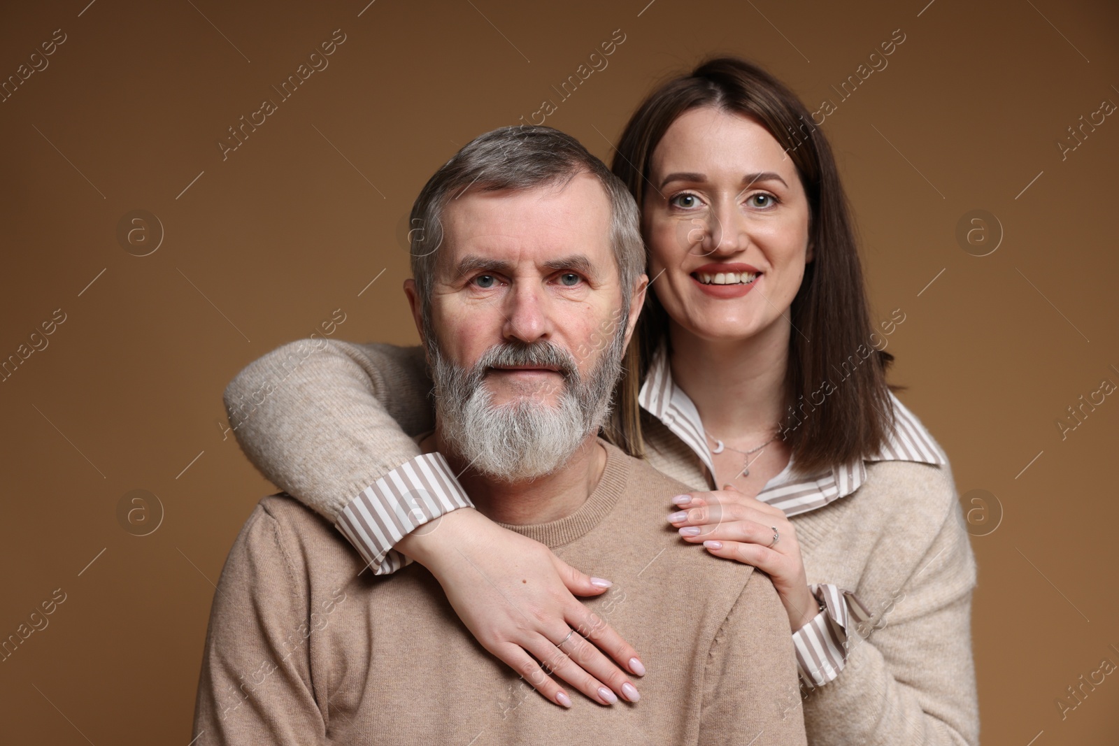 Photo of Family portrait of happy daughter and her father on brown background