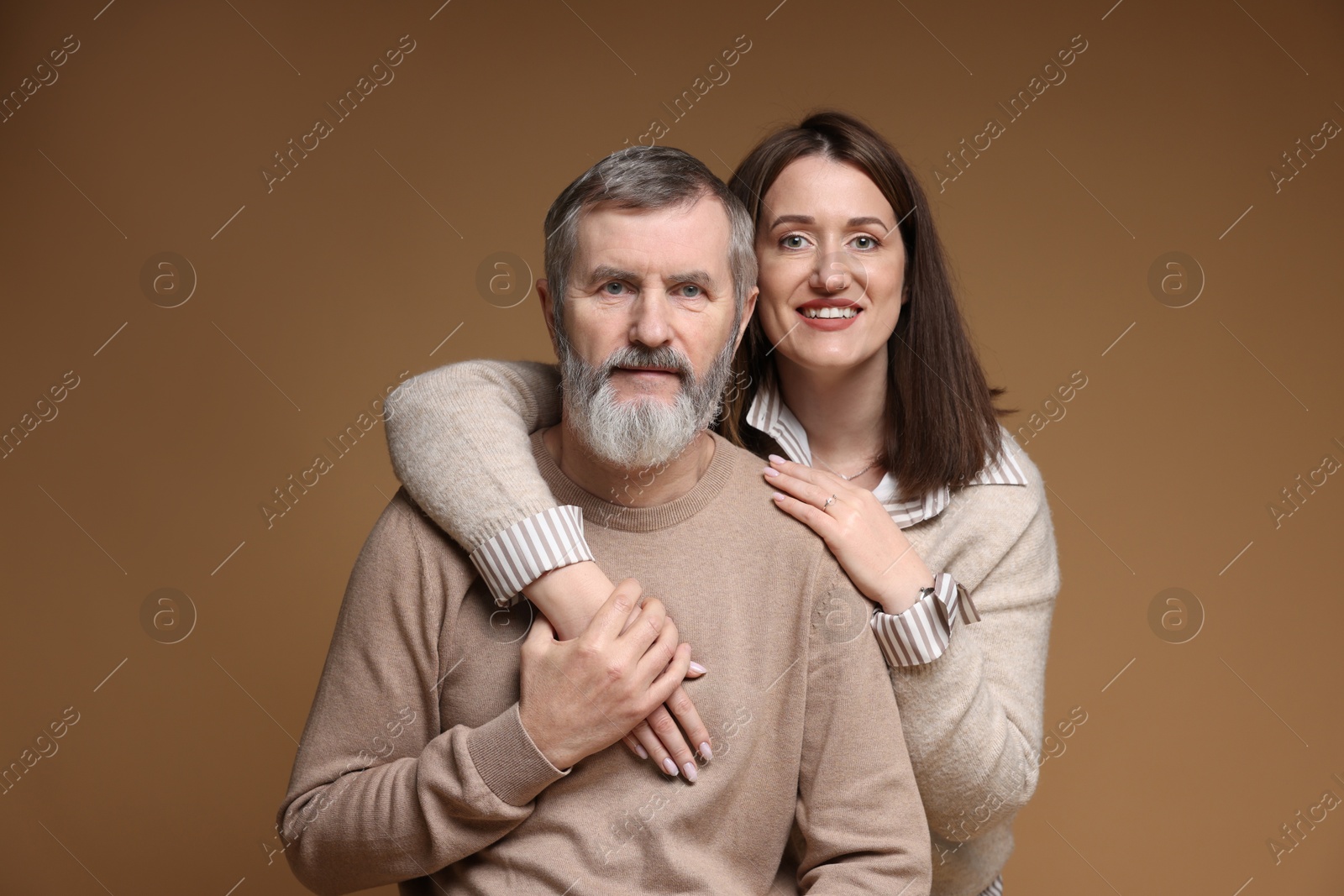 Photo of Family portrait of happy daughter and her father on brown background