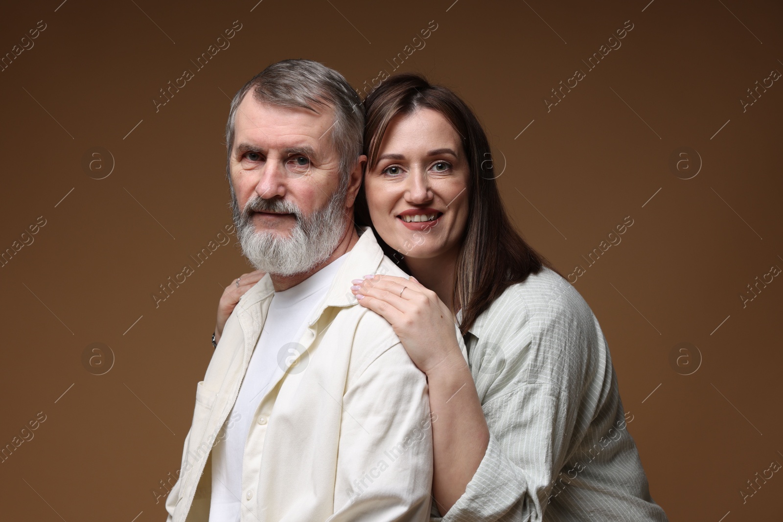 Photo of Happy daughter and her father on brown background