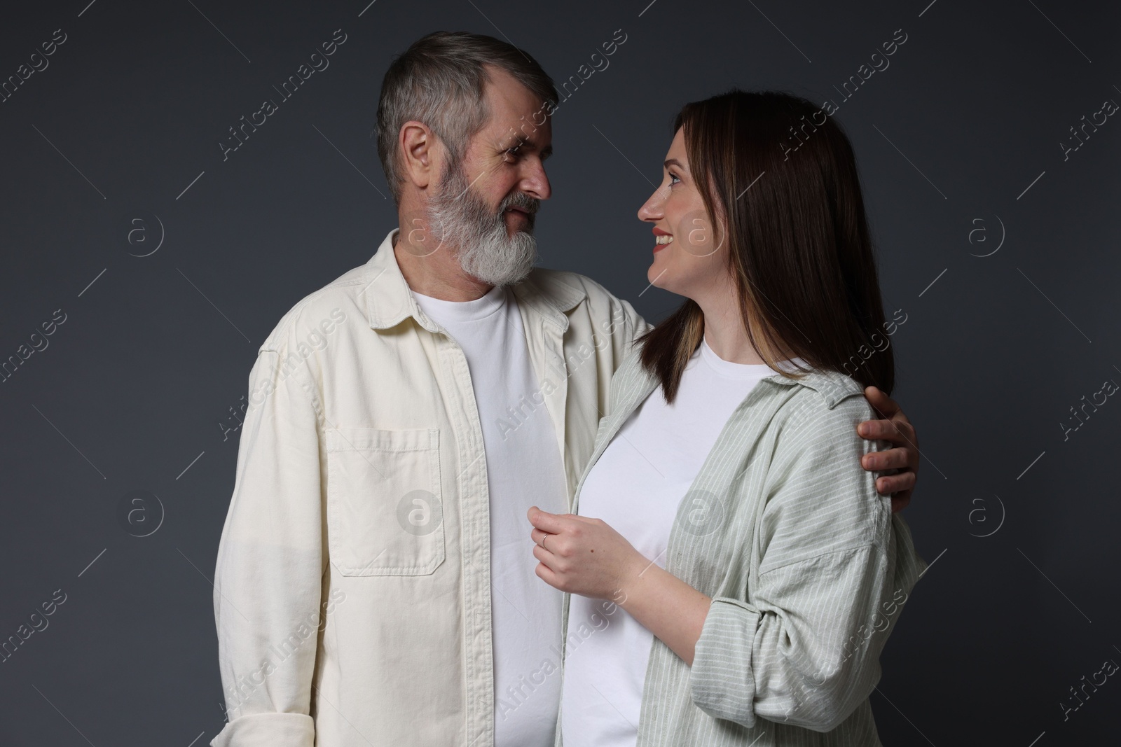 Photo of Happy daughter and her father on dark background