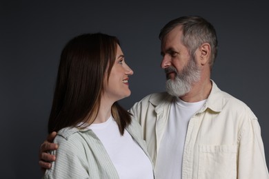 Photo of Happy daughter and her father looking at each other on dark background