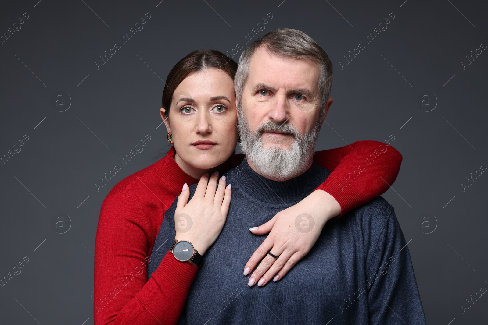 Photo of Family portrait of daughter hugging her father on dark background