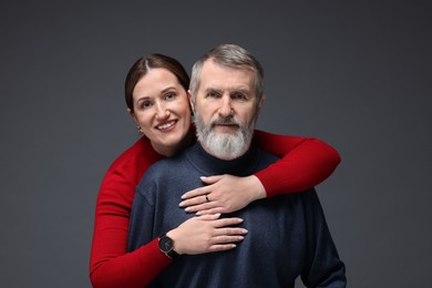 Photo of Family portrait of happy daughter hugging her father on dark background