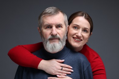 Photo of Family portrait of happy daughter hugging her father on dark background