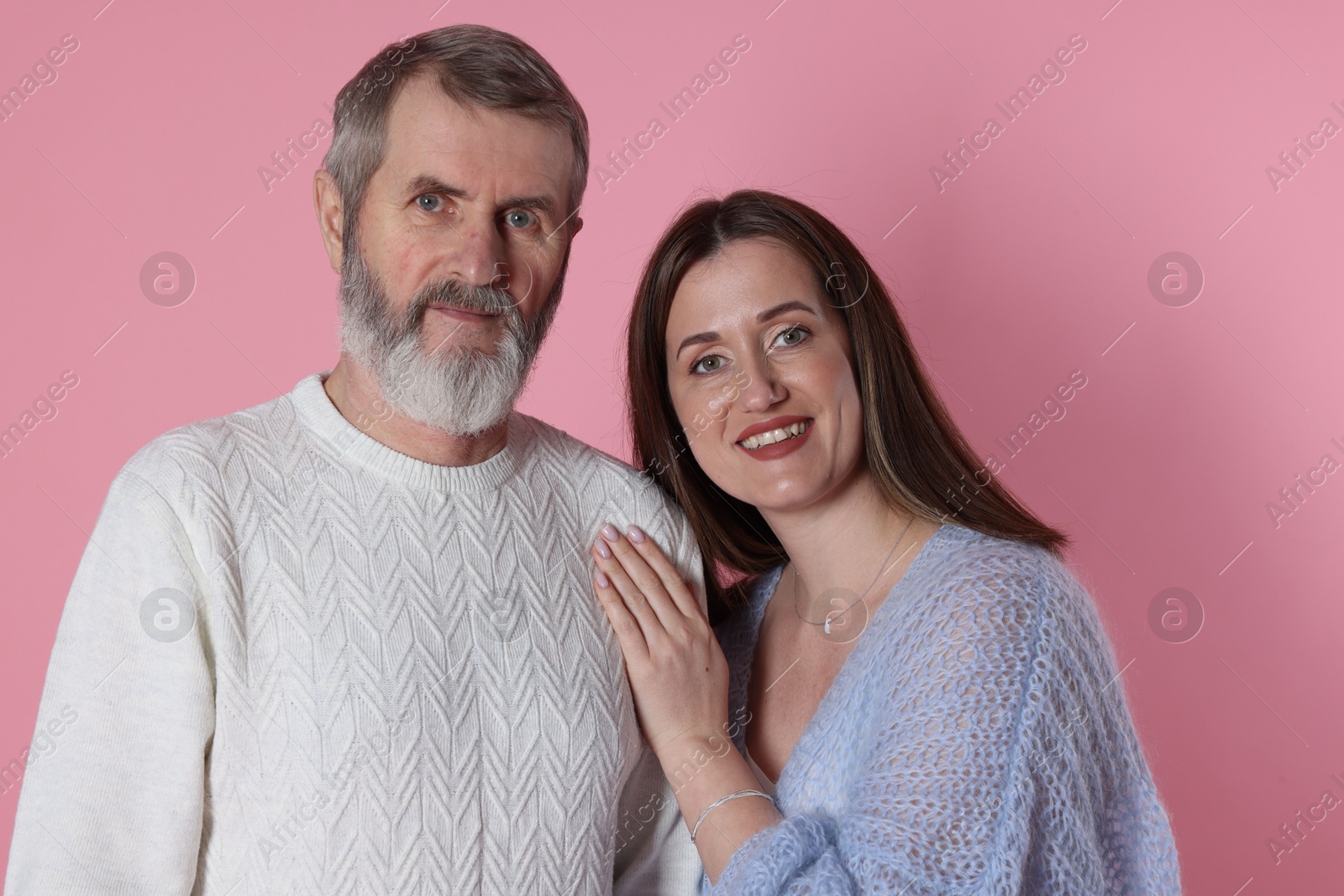 Photo of Family portrait of happy daughter and her father on pink background