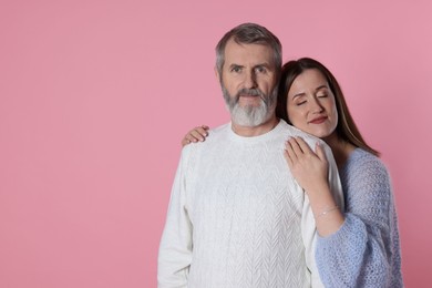 Photo of Family portrait of daughter and her father on pink background, space for text