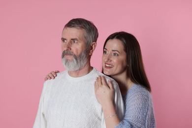 Photo of Happy daughter and her father on pink background