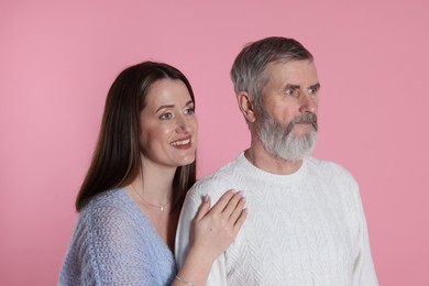 Photo of Happy daughter and her father on pink background