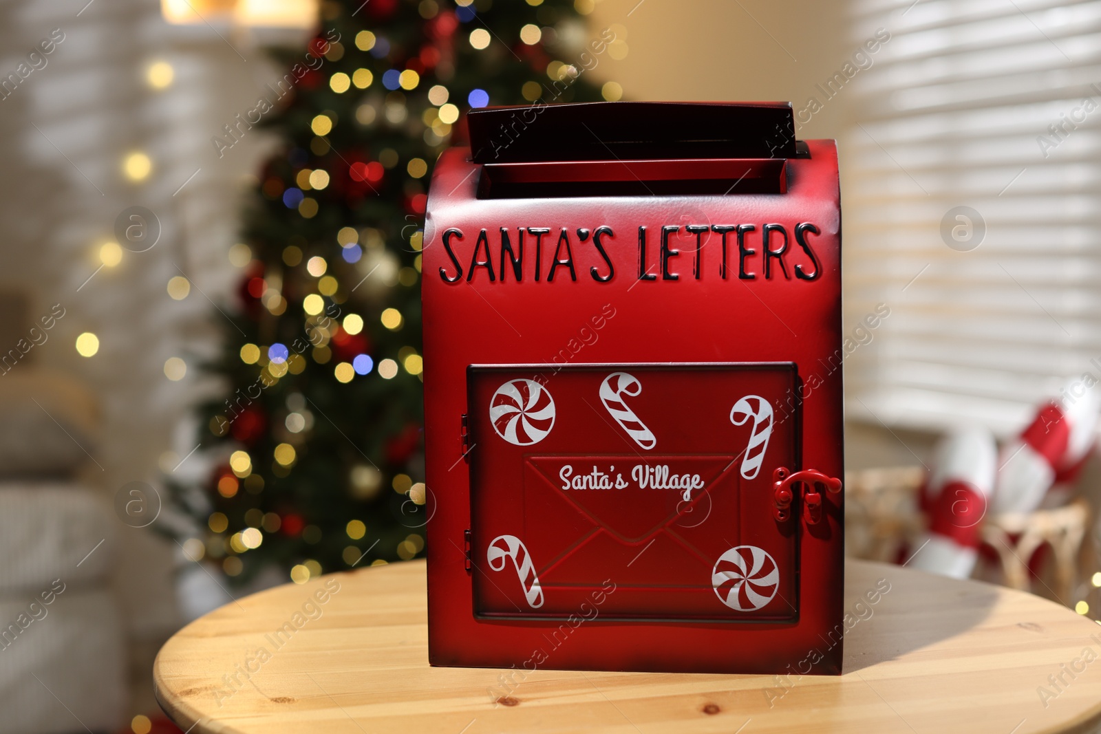 Photo of Santa Claus mailbox on wooden table indoors. Christmas tradition